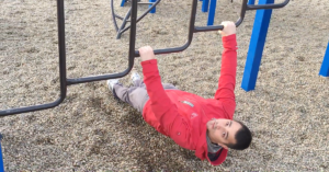 Man doing an Australian pull-up on a playground.